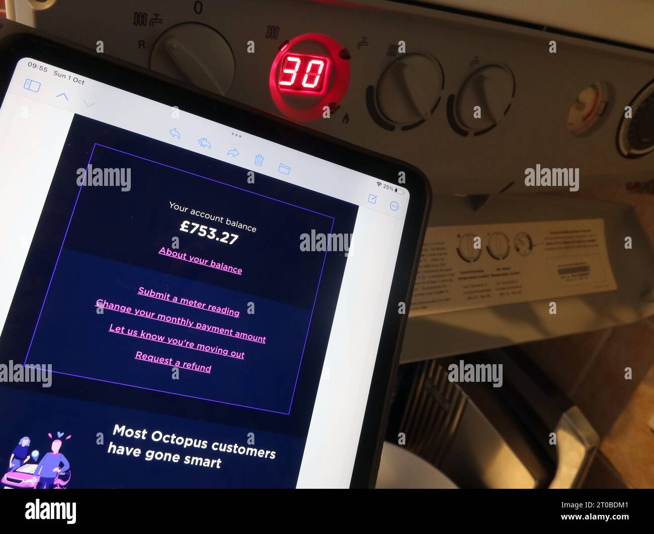 iPad tablet with Octopus monthly costs, near central heating boiler, in domestic property, semi-detached home, Cheshire, England, UK Stock Photo