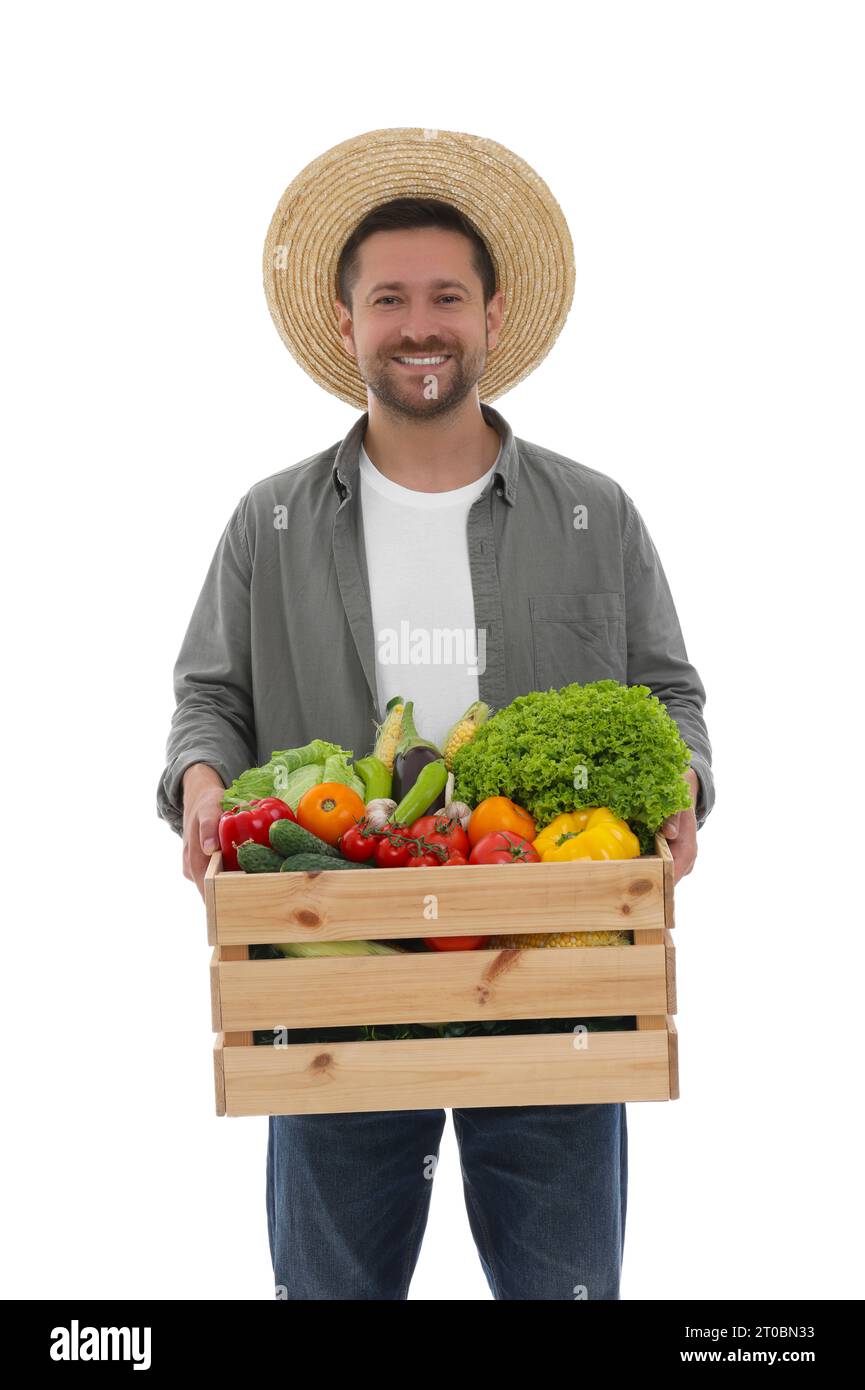 Harvesting season. Happy farmer holding wooden crate with vegetables on ...