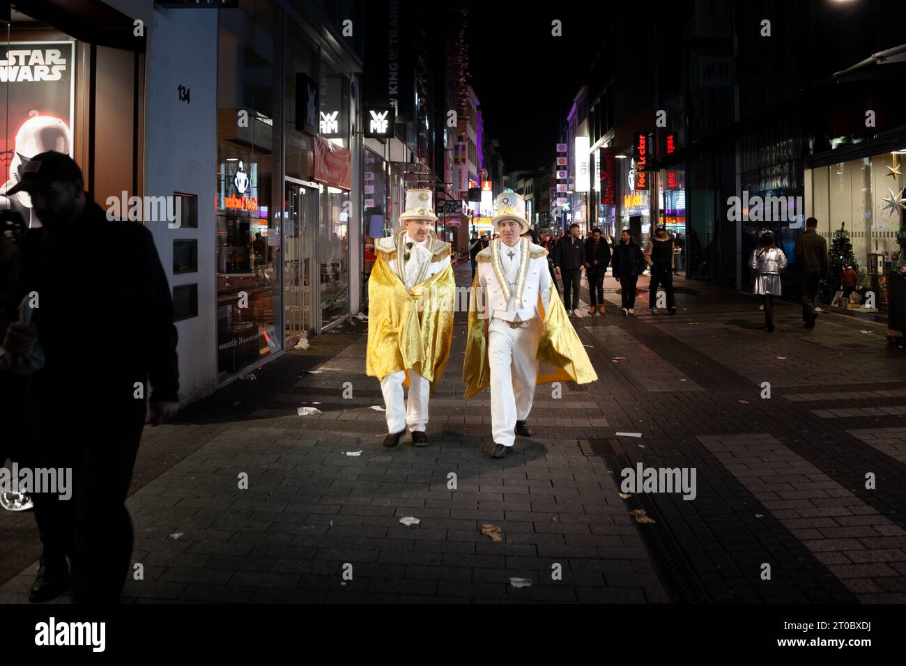 Picture of people dressed in white costumes for Cologne Carnival in Cologne, Germany at night. The Cologne Carnival (German: Kölner Karneval) is a car Stock Photo