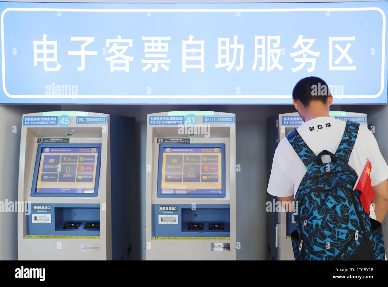 QINGDAO, CHINA - OCTOBER 5, 2023 - A passenger picks up a return ticket at the self-service area of Qingdao Railway Station in Qingdao, East China's S Stock Photo