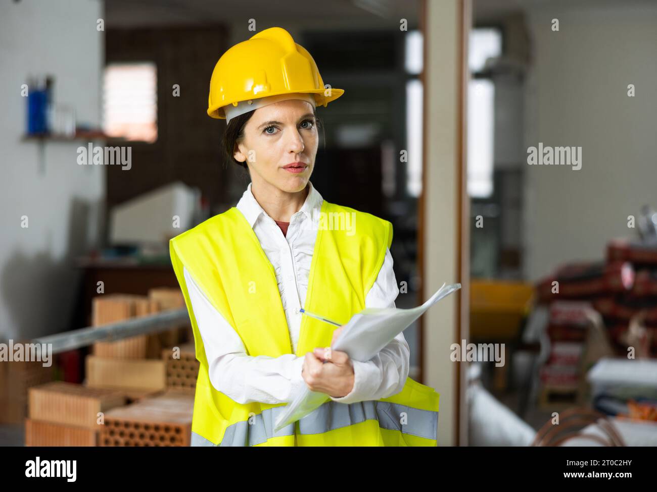 Female architect making list of tasks while supervising building under