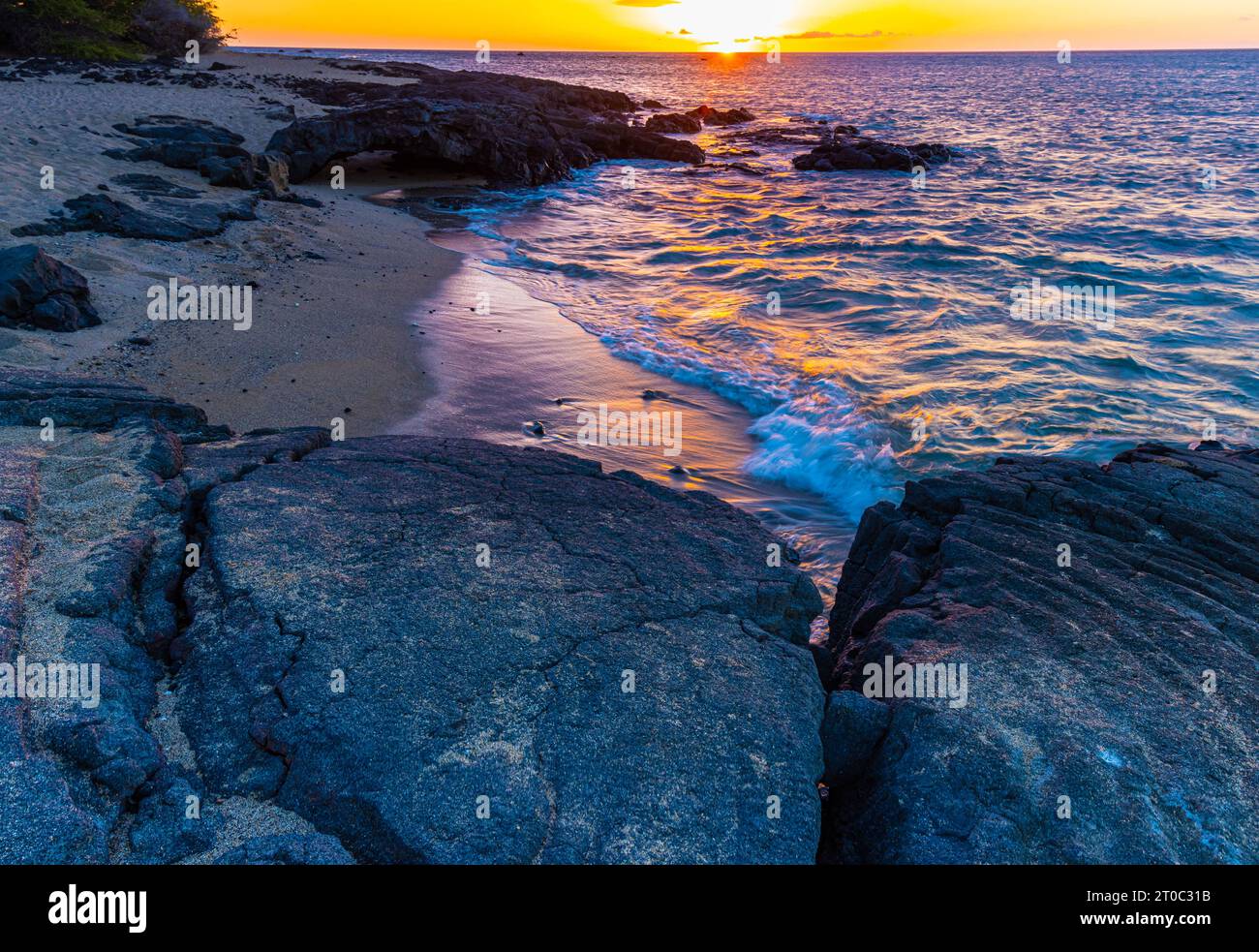 Sunset Over Kapalaoa Beach and Lava Reef on  Anaehoʻomalu Bay, Hawaii Island, Hawaii, USA Stock Photo