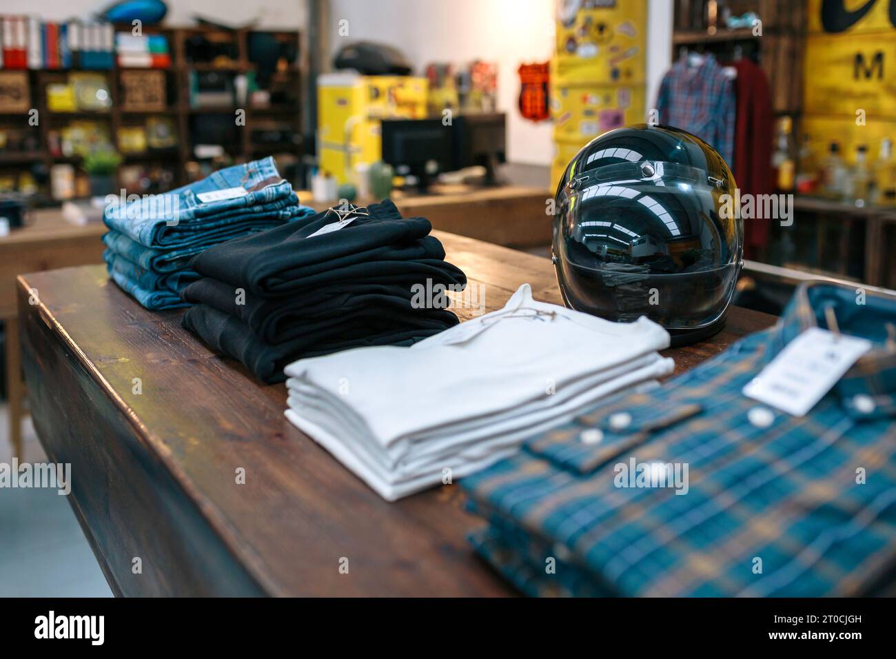 Black motorbike helmet and new clothes collection over counter on
