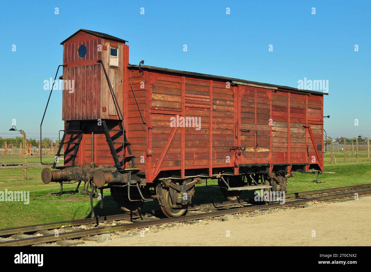 An original red wagon from the infamous 'Holocaust trains' at the Auschwitz Birkenau Concentration Camp. Poland, October 2012 Stock Photo