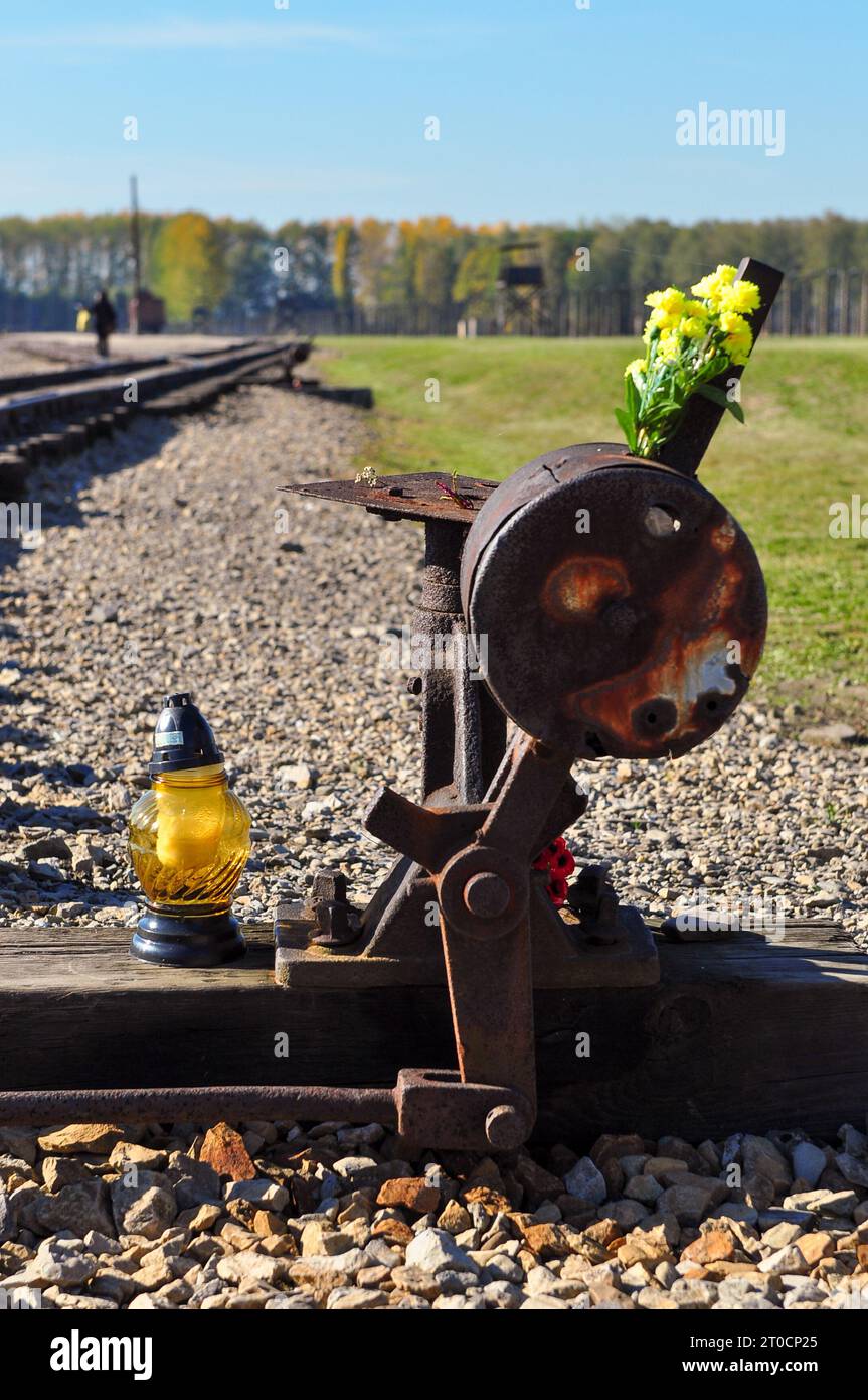 Lamp and flowers shrine by the railroad track in Auschwitz Birkenau, Poland, October 2012 Stock Photo
