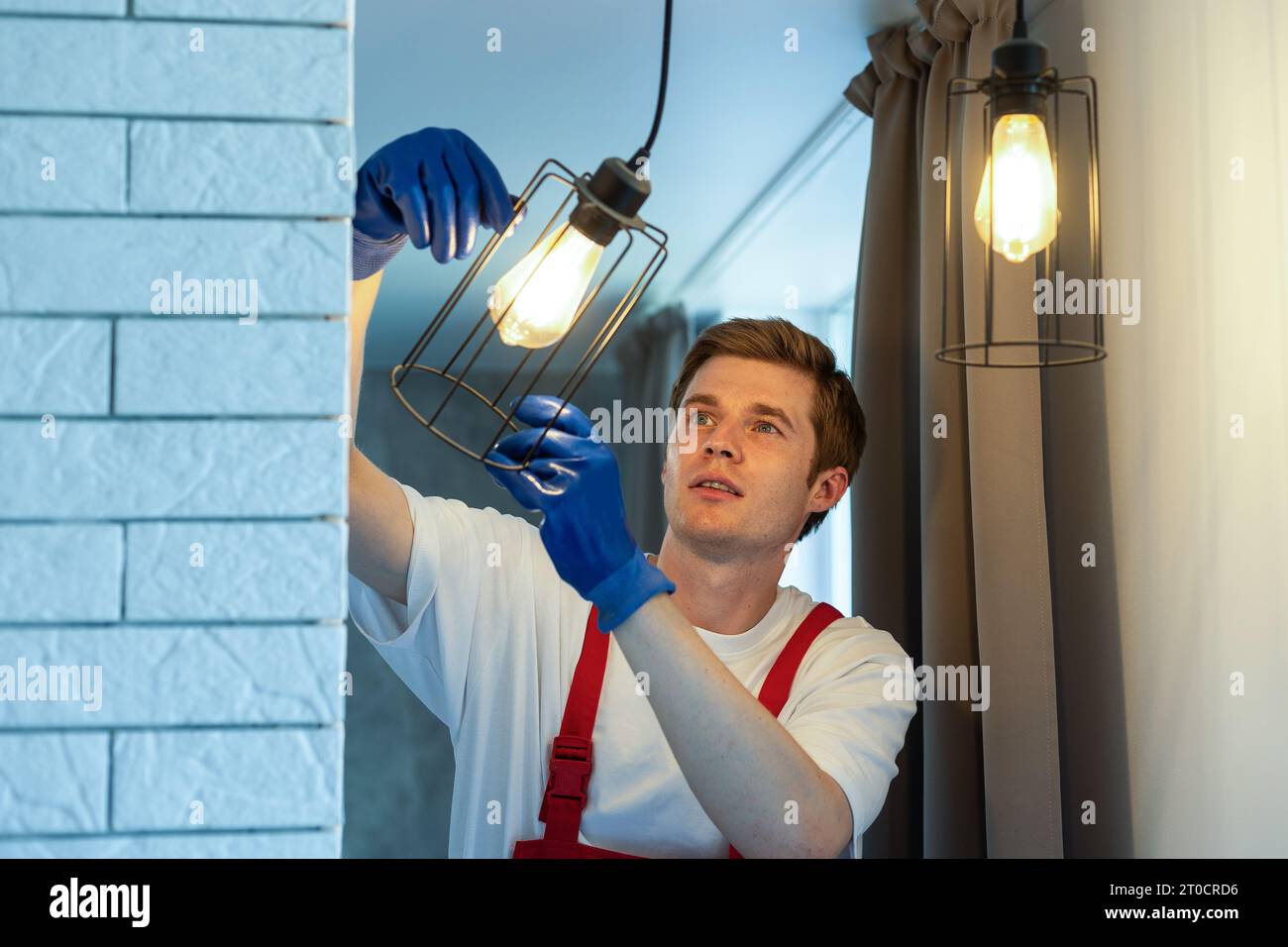An electrician is installing LED spotlights on the ceiling Stock Photo ...