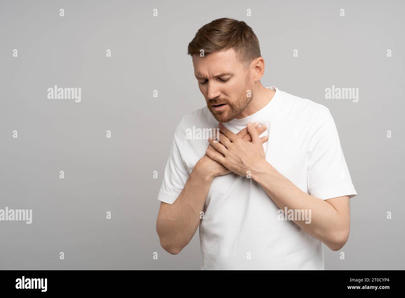 Man holds on to chest, suffering from heartburn. Acute pain