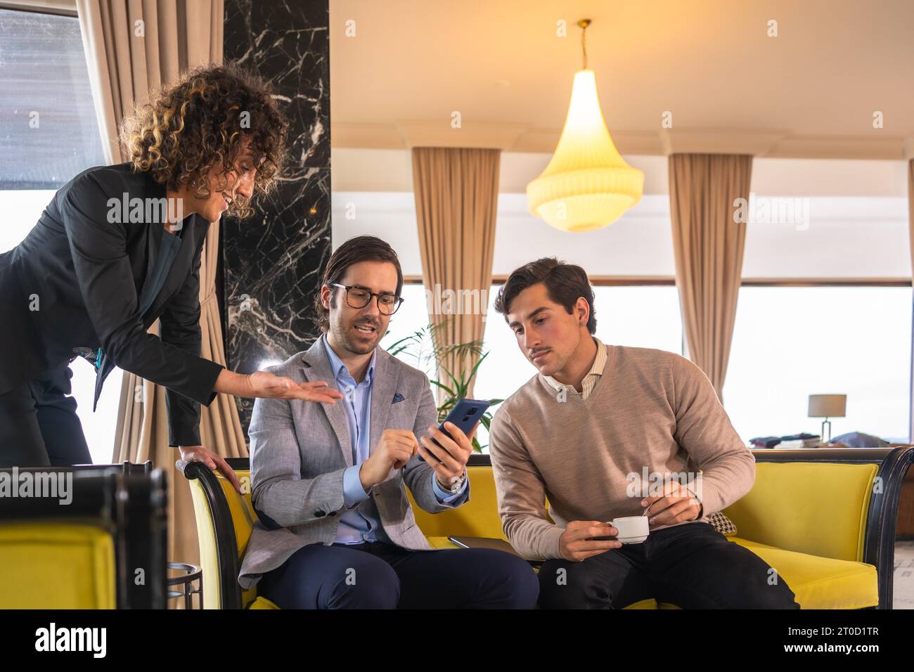 Woman explaining a project sharing a mobile phone during a business