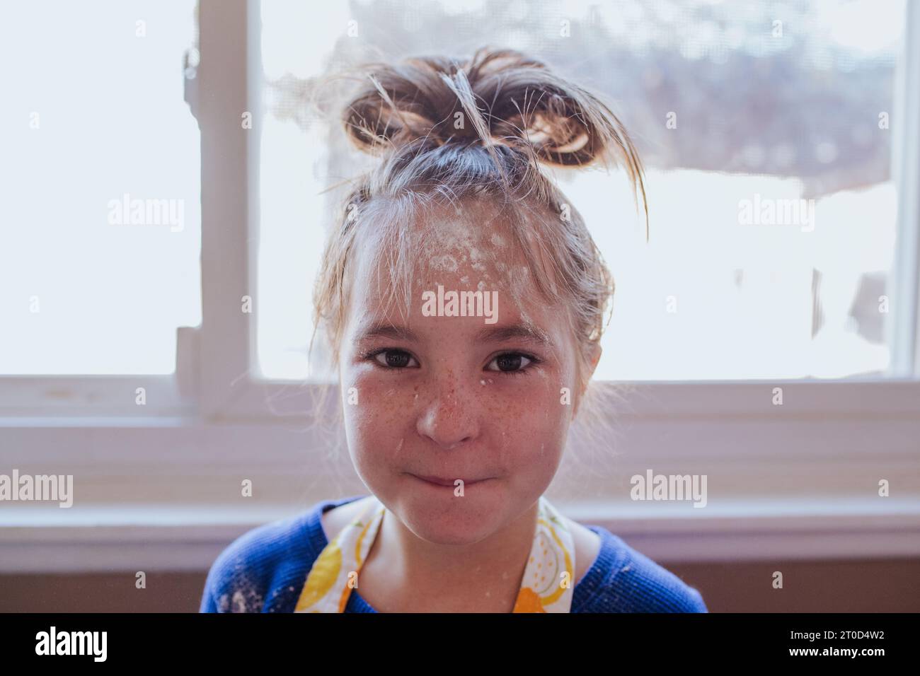Young girl covered in flour from baking Stock Photo Alamy