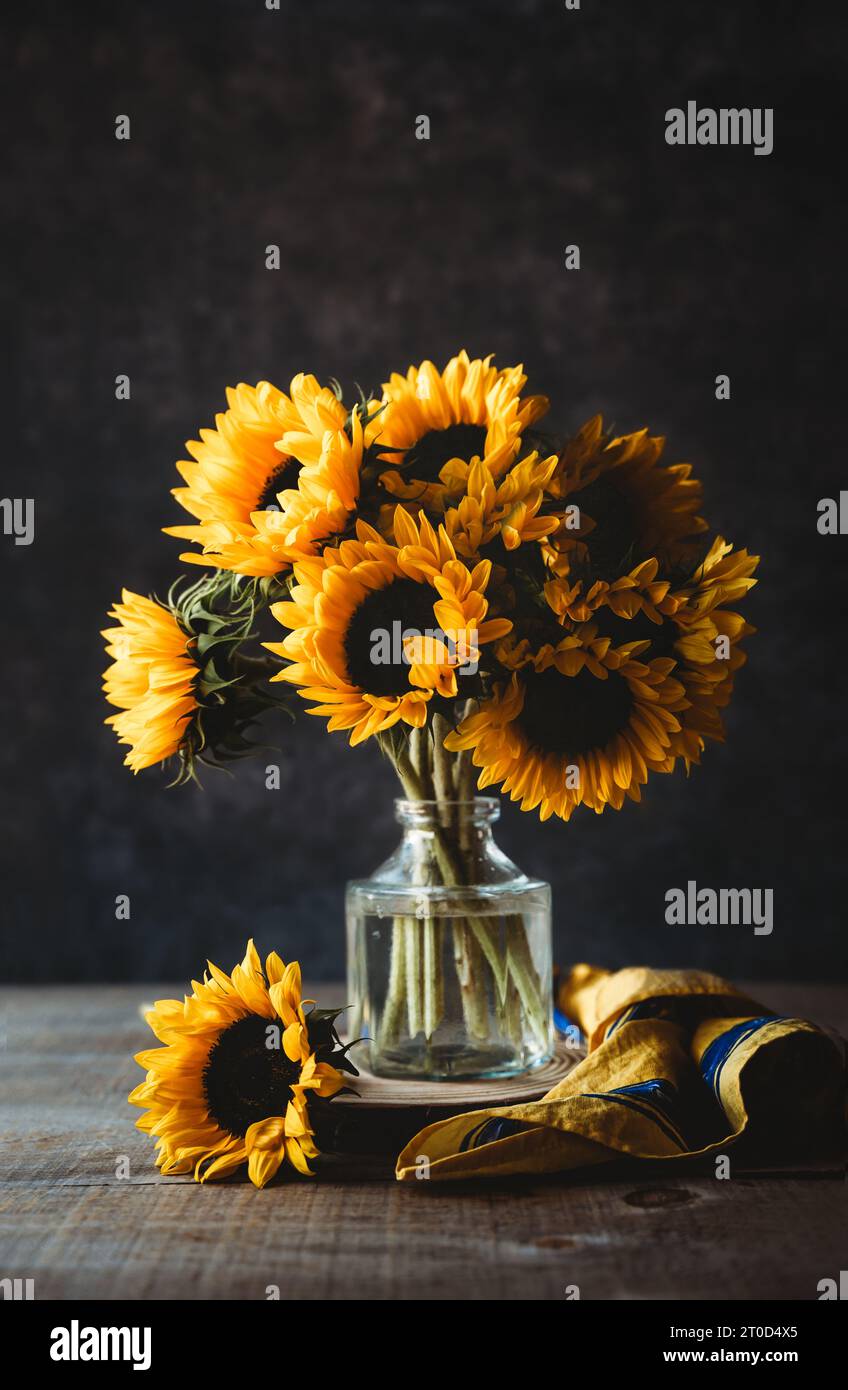 Bouquet of sunflowers in vase against dark background Stock Photo - Alamy