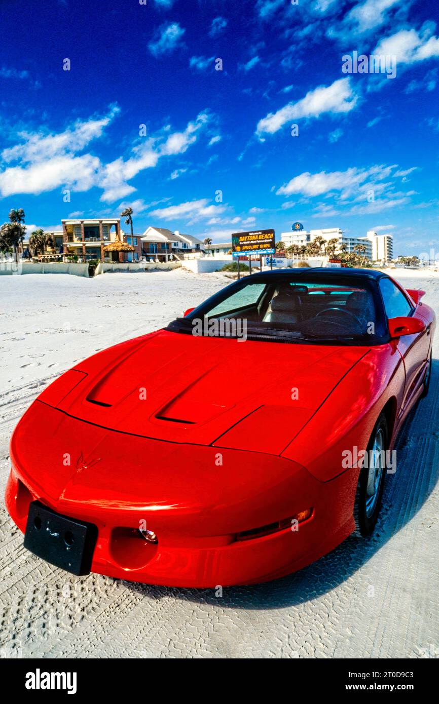 Red Pontiac Firebird Trans Am 1995 series 3 model parked on the sand at Daytona Beach, Florida, USA Stock Photo
