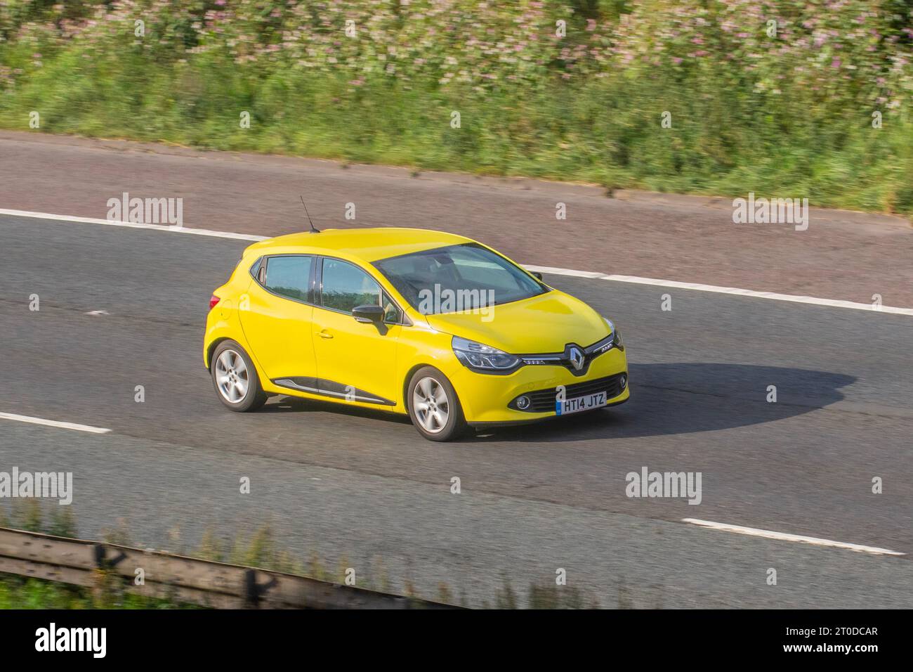 2014 Renault Clio D-Que M-Nav Energy Dci Ss Dci 90 Energy Start/Stop Yellow Car Hatchback Diesel 1461 cc; travelling at speed on the M6 motorway in Greater Manchester, UK Stock Photo