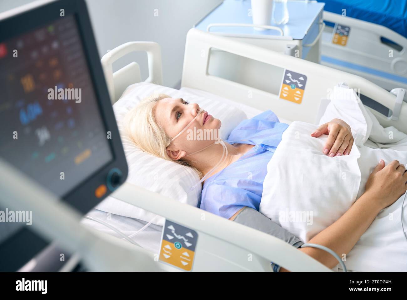 Woman after surgery lies in a room with modern equipment Stock Photo