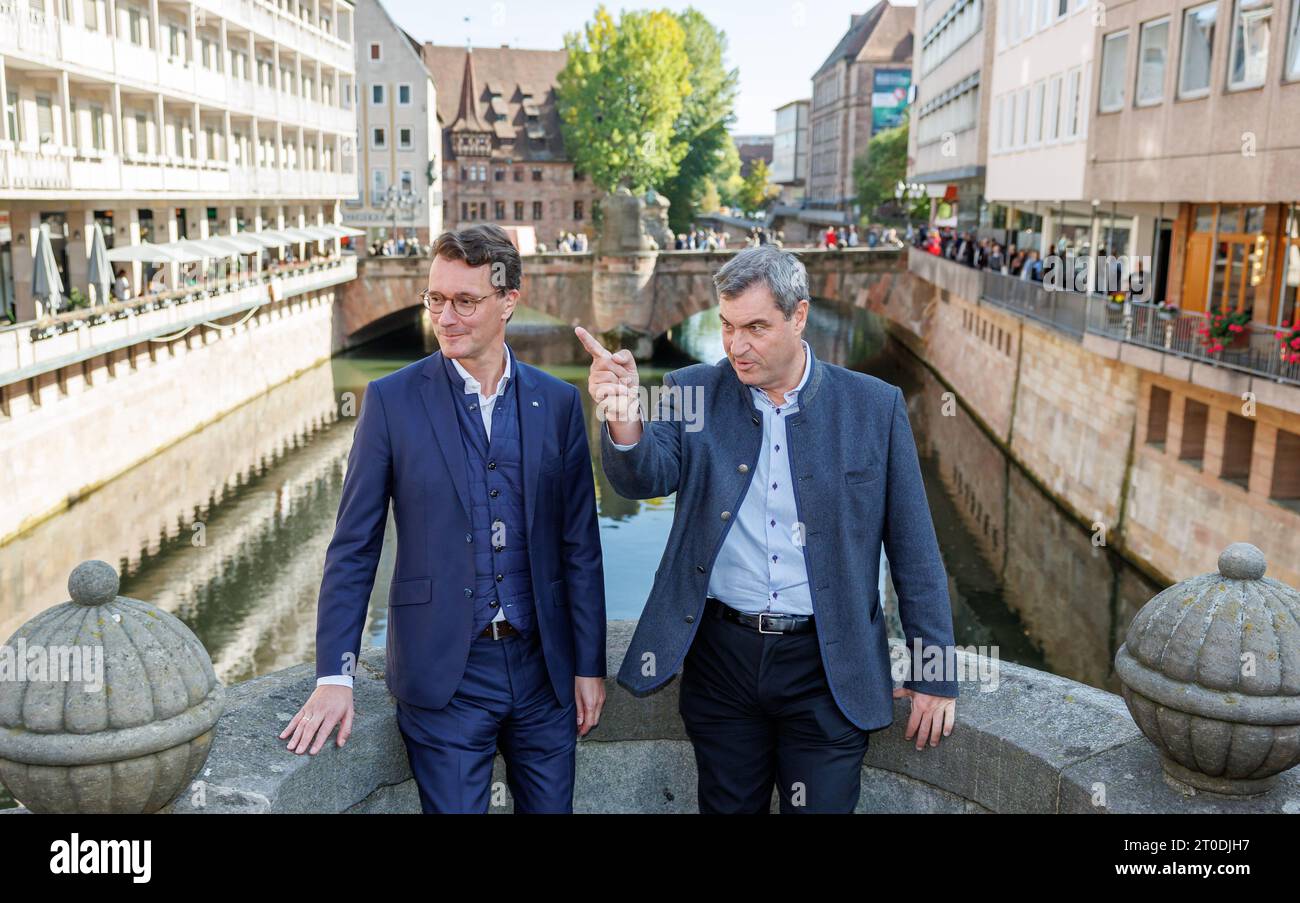 Nuremberg, Germany. 06th Oct, 2023. Markus Söder (CSU, r), Prime Minister of Bavaria, and Hendrik Wüst (CDU), Prime Minister of North Rhine-Westphalia, stand on the Fleischbrücke during a walk through Nuremberg's old town. The two Union politicians met in Nuremberg before the end of the election campaign, walked through the old town and then had lunch together with members of the Bavarian state parliament. Credit: Daniel Karmann/dpa/Alamy Live News Stock Photo