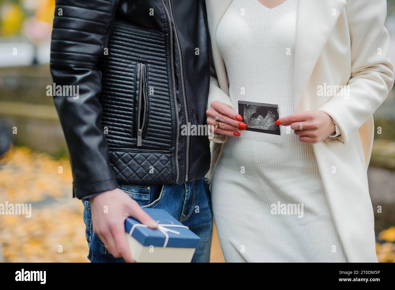 A man hugs his pregnant wife. Woman holding ultrasound photo of baby ...