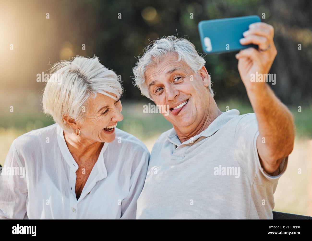 Senior couple, tongue and selfie in outdoor nature garden for love memory, connection and retirement emoji. Elderly man, funny face and laughing woman Stock Photo