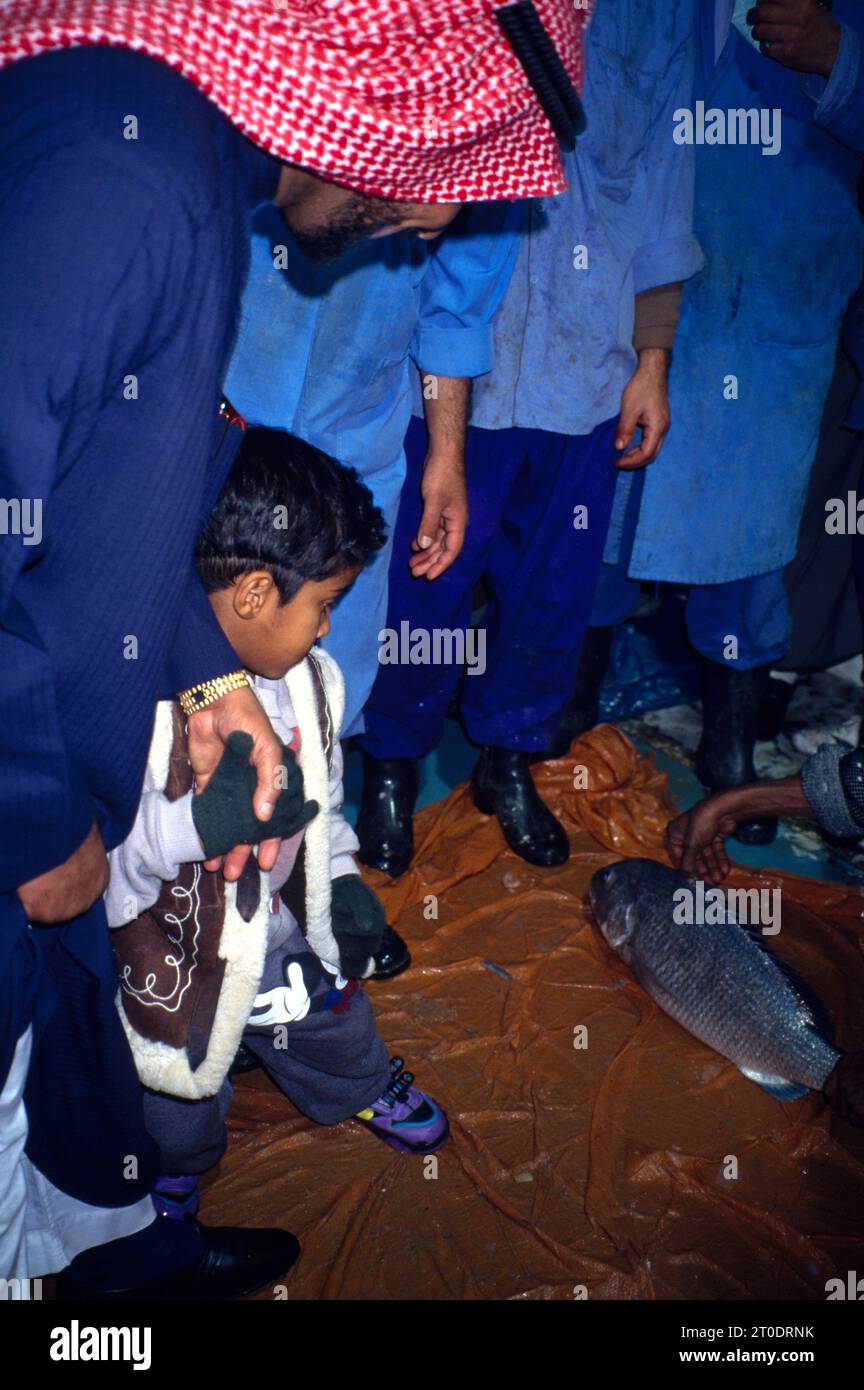 Kuwait City Kuwait Fish Market Man And son looking at Fish Stock Photo