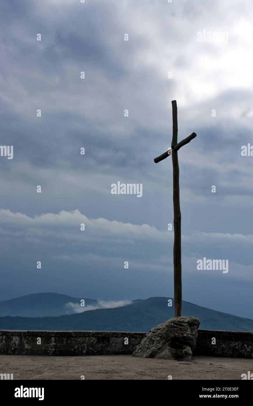 La croce dell'eremo della Verna contro il cielo nuvoloso Stock Photo