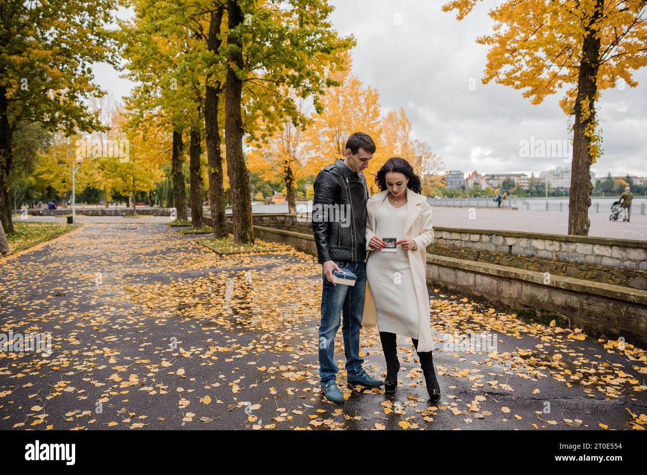 A man hugs his pregnant wife. Woman holding ultrasound photo of baby ...