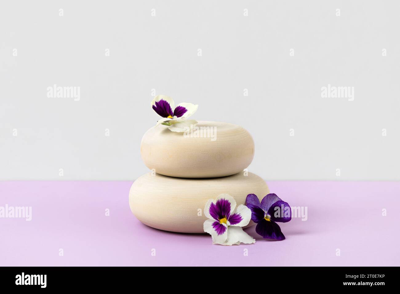 Wooden round podium pedestal cosmetic beauty product presentation empty mockup on lilac pastel background with white flowers. Stock Photo