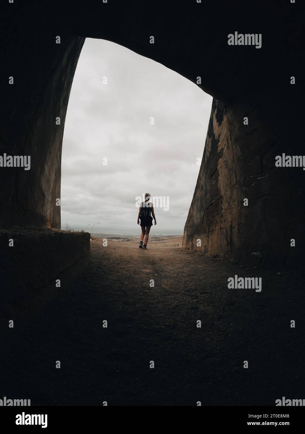 Figure of a woman standing out at the exit of a cave Stock Photo