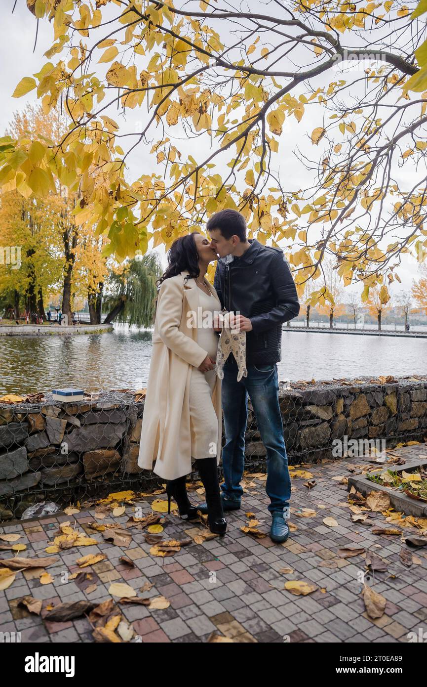 A man hugs his pregnant wife. Woman holding baby's pants Stock Photo ...