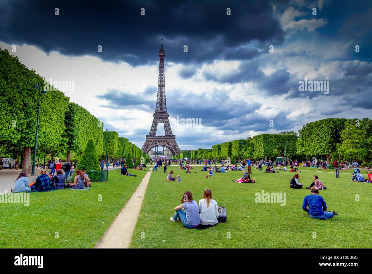 Paris 7th arrondissement. The Champ de Mars with tourists at the foot of Eiffel tower. Paris Ile de France. France Stock Photo