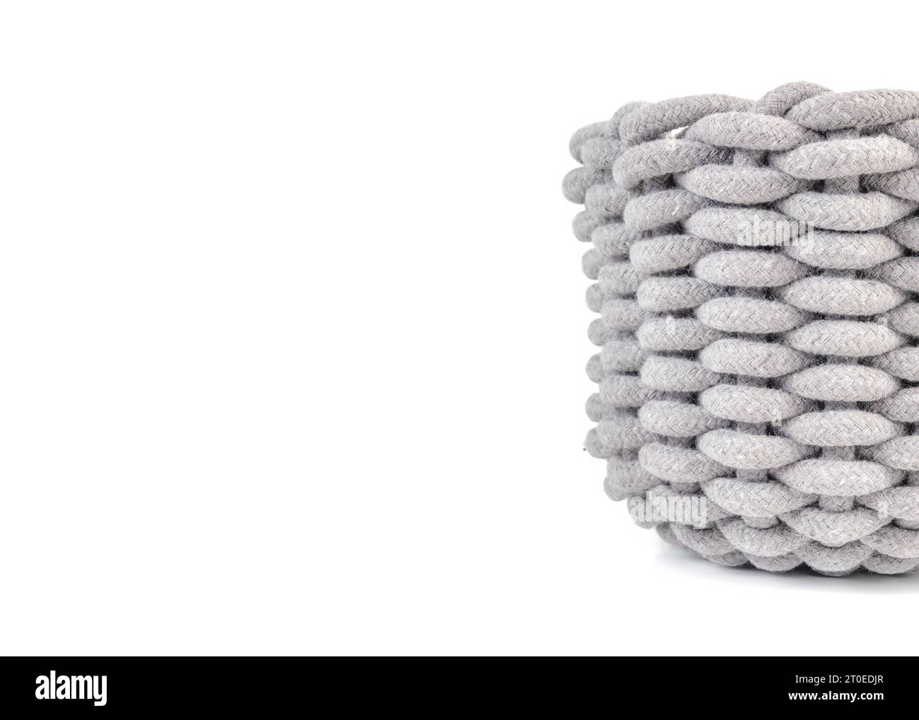 Isolated woven basket. Partial front view of light grey large storage basket made of woven cotton rope. Textile background texture or surface. Selecti Stock Photo