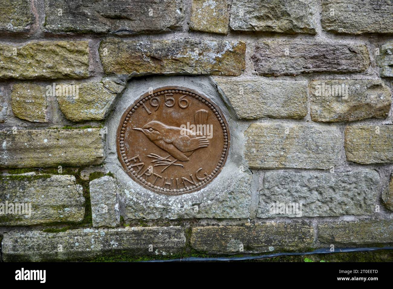 A large farthing built into a wall in New Mills, Derbyshire Stock Photo