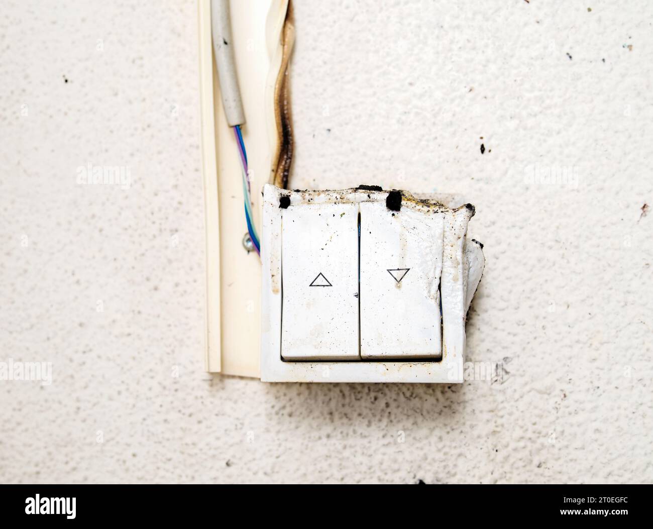 Melted light switch after a house fire. Front view of light regulator caught on fire. Yellow