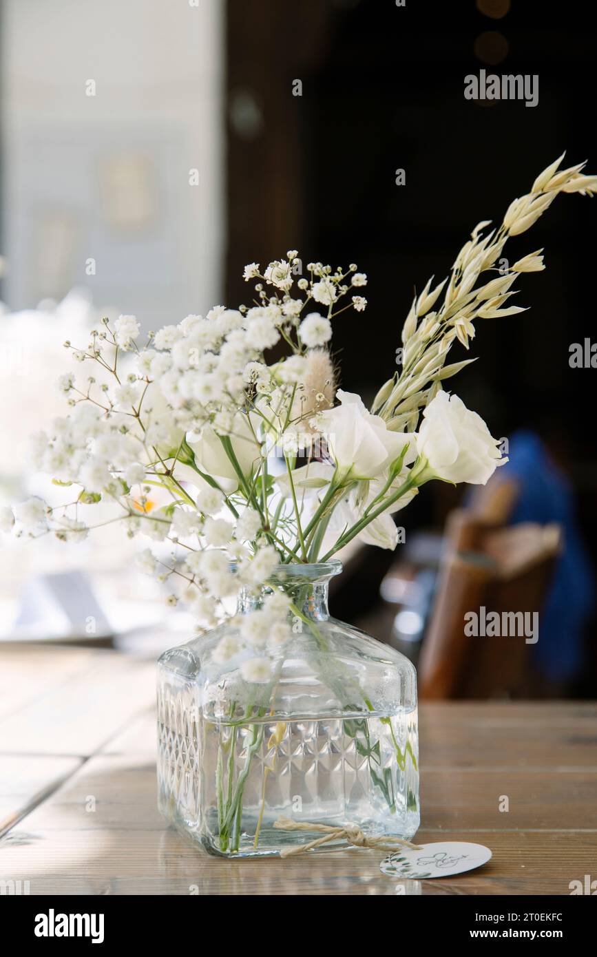 Small flower vase with a decorative bouquet of white flowers Stock Photo
