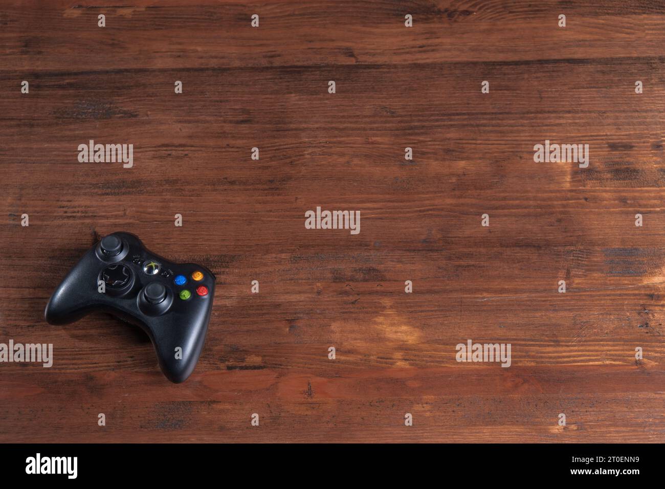 An isolated gaming controller rests on a table, with no other items present Stock Photo