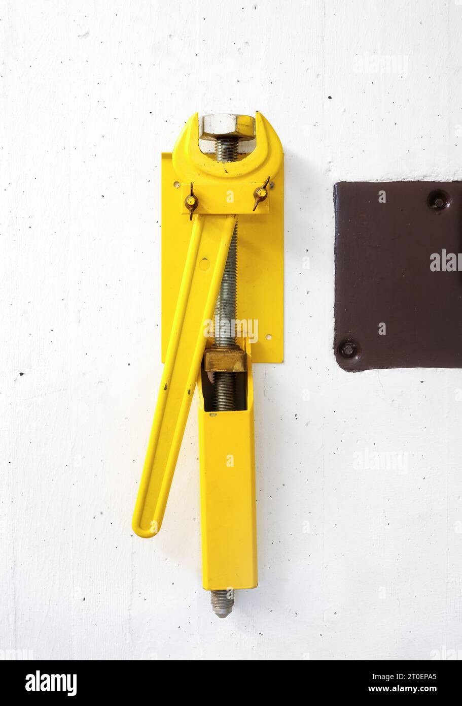 Wrench and pry bar on blast door in bomb shelter in building in Switzerland. Heavy duty yellow large wrench. Fallout shelter or survival shelter used Stock Photo