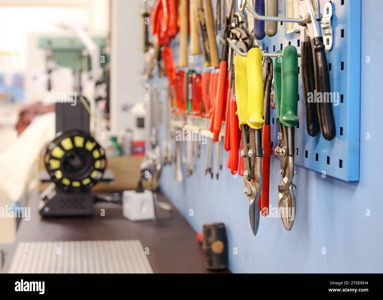 Variety of pliers, screw drivers and hammers mounted at the wall in the