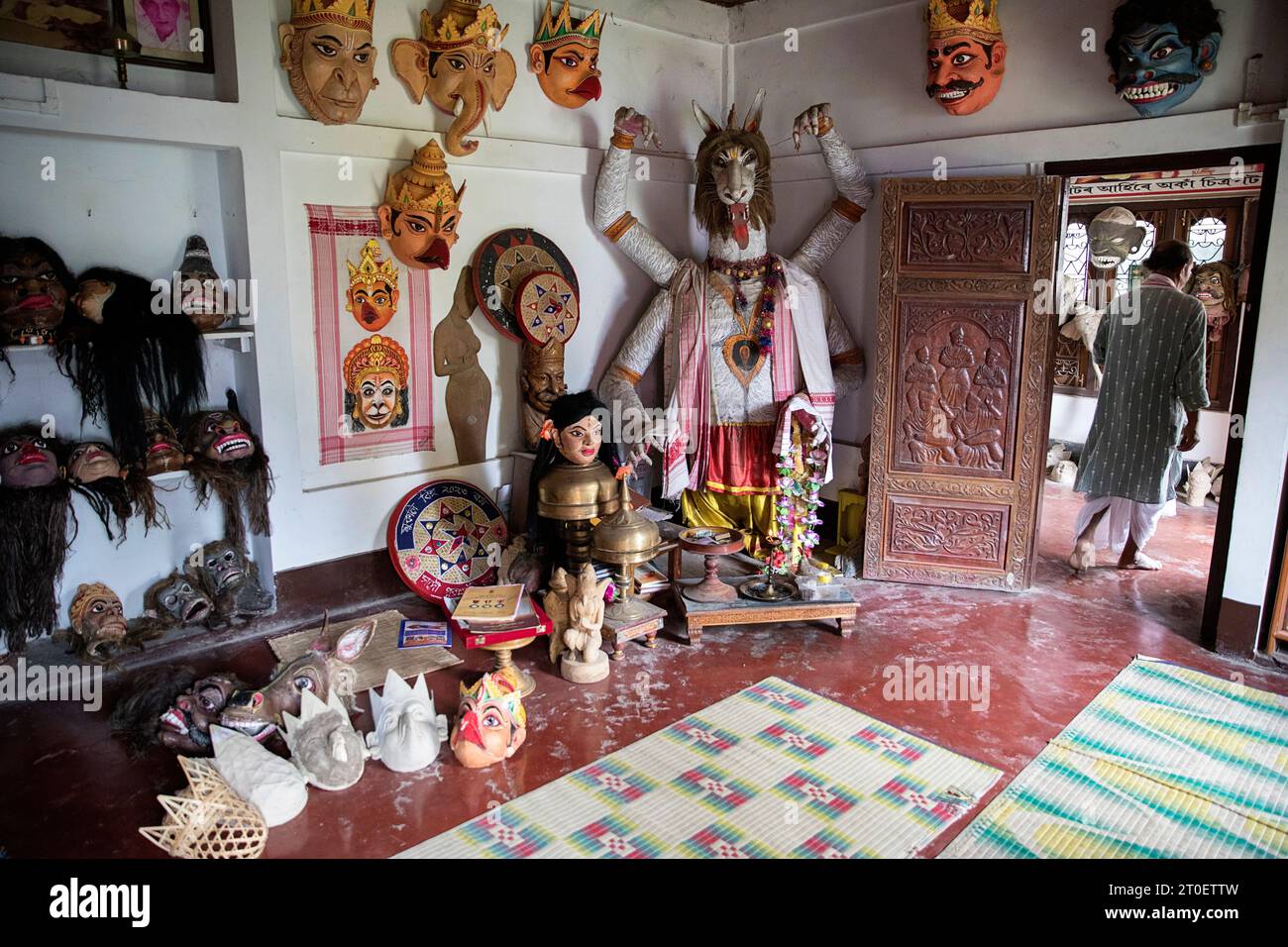 Room full of traditional masks made by world famous mask maker Hem Chandra Goswami, that is leaving the room, on Majuli island in Assam, India Stock Photo