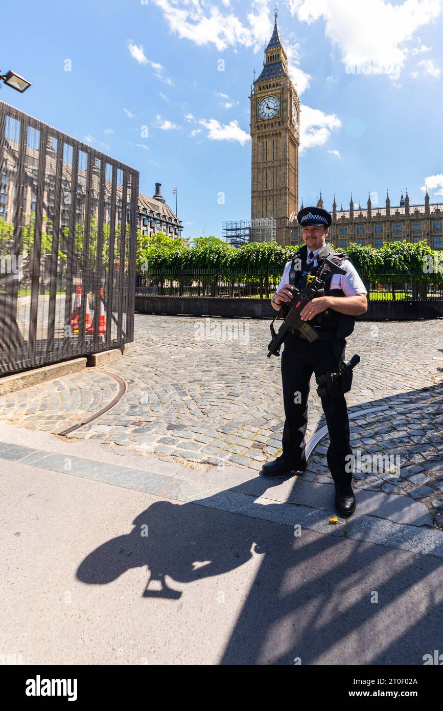 Armed British policeman guarding the gate to the Houses of Parliament, Palace of Westminster. London, UK. Authorised Firearms Officer of The Met Stock Photo