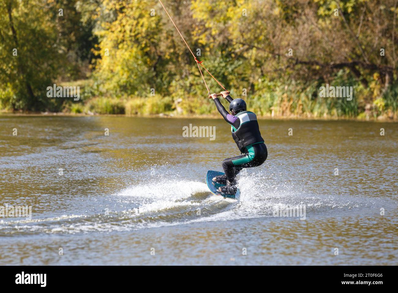 A woman surfing on wakeboard along the river. Stock Photo