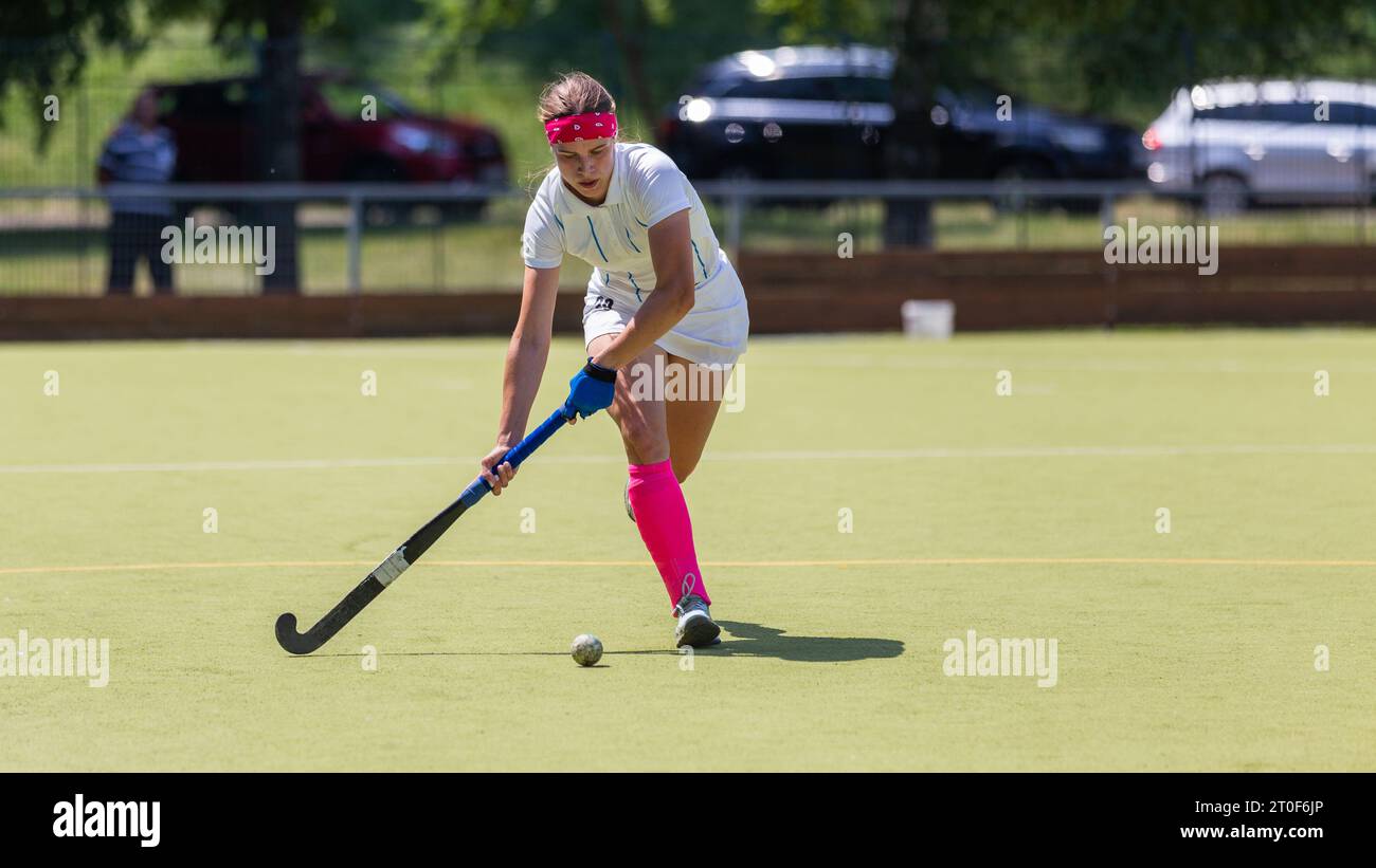 Young female player running with ball in attack on the pitch in field