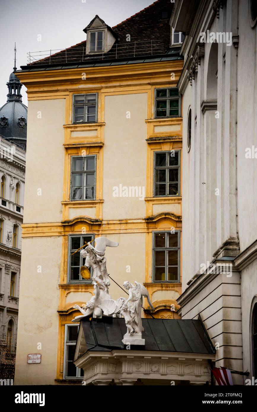 Sculpture of Archangel Michael slaying lucifer on St. Michael's Church in Vienna, Austria sitting beside the Grobes Michaelerhaus. Stock Photo