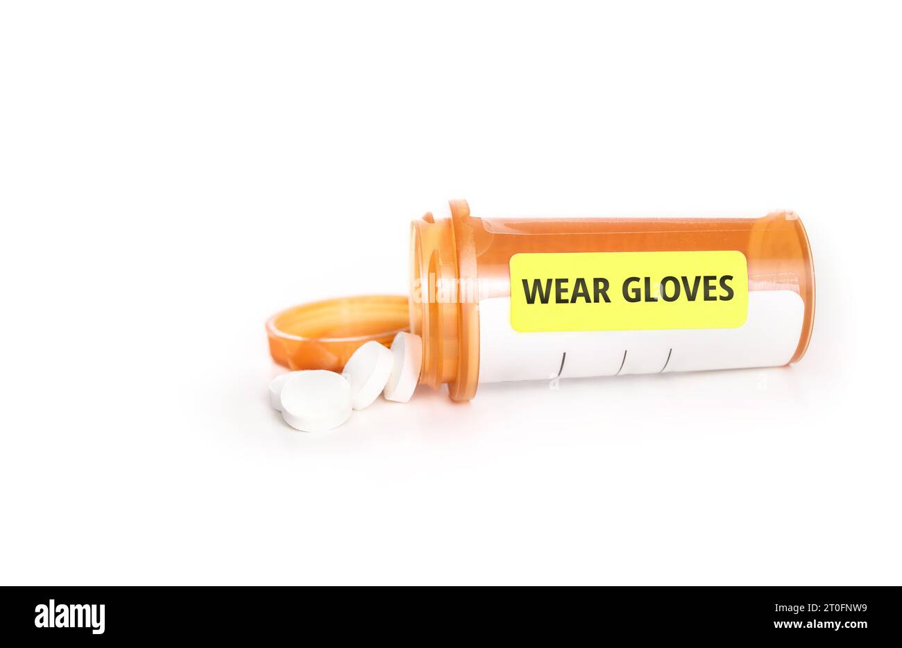Pill bottle with wear glove label for chemotherapy or hazard medicines. Orange prescription bottle with pills falling out. For humans, pets or animals Stock Photo