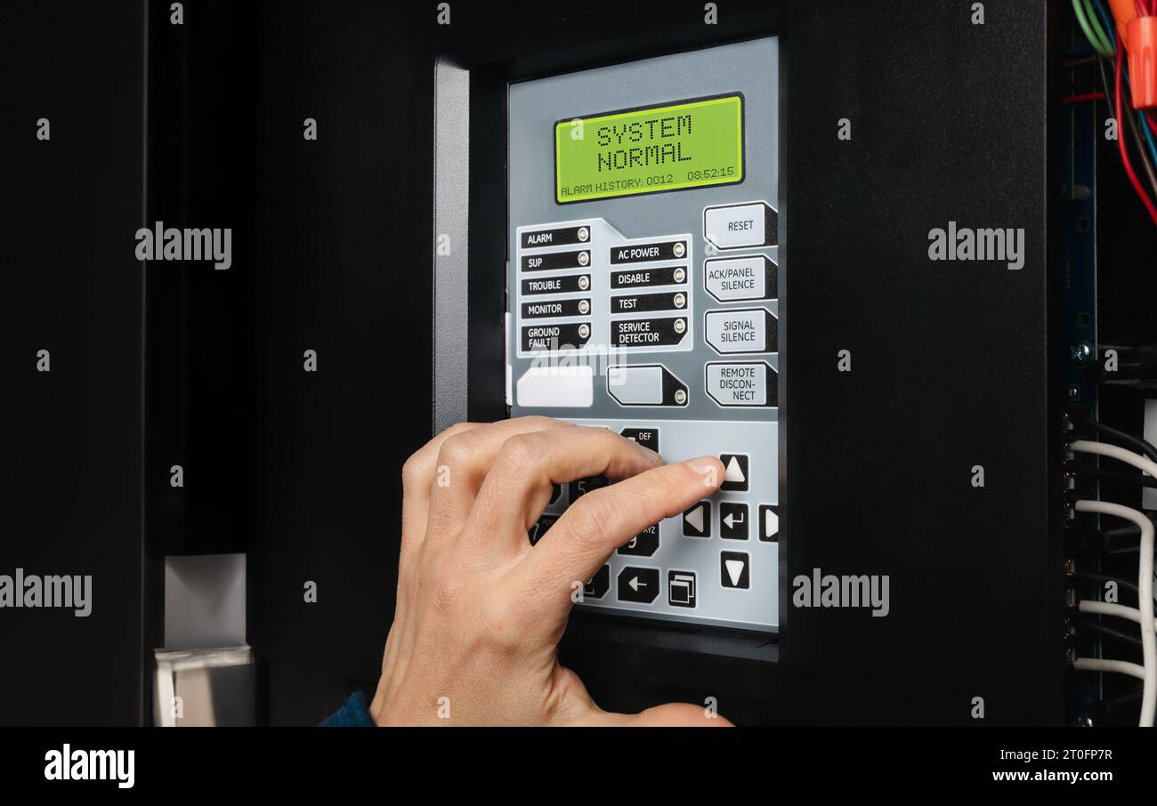 Technician using fire alarm control panel in service room. Singlestage