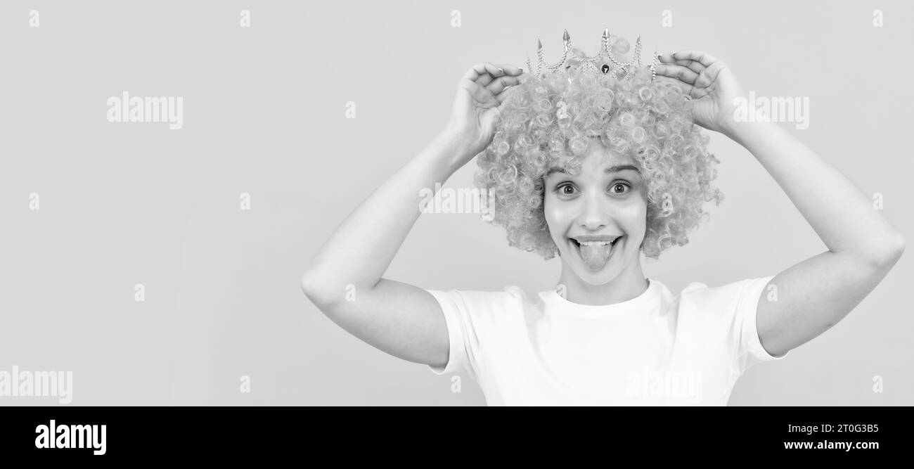 happy egoistic funny girl with fancy look wearing orange hair wig and princess crown, winner. Woman isolated face portrait, banner with copy space. Stock Photo