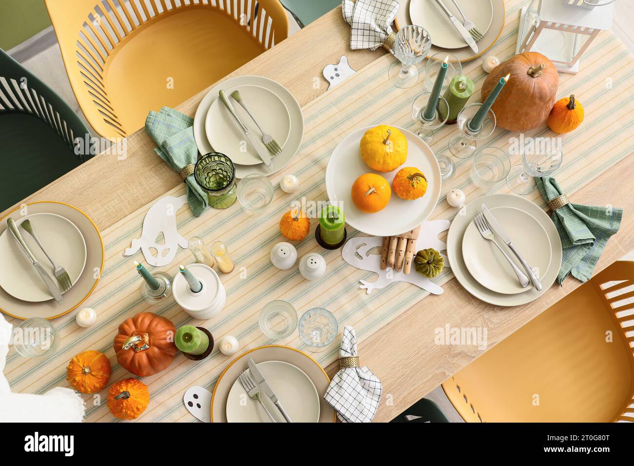 Festive table setting with pumpkins, burning candles and ghosts for ...