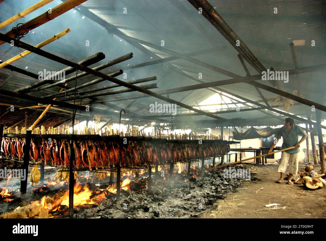A worker maintains the equal distribution of coconut husks that are