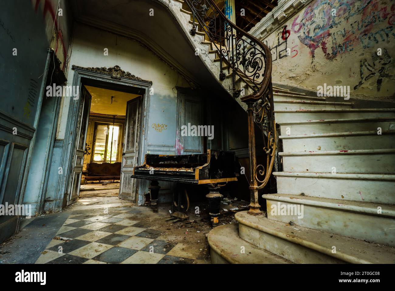 empty hallway with an old broken piano in an abandoned mansion Stock Photo