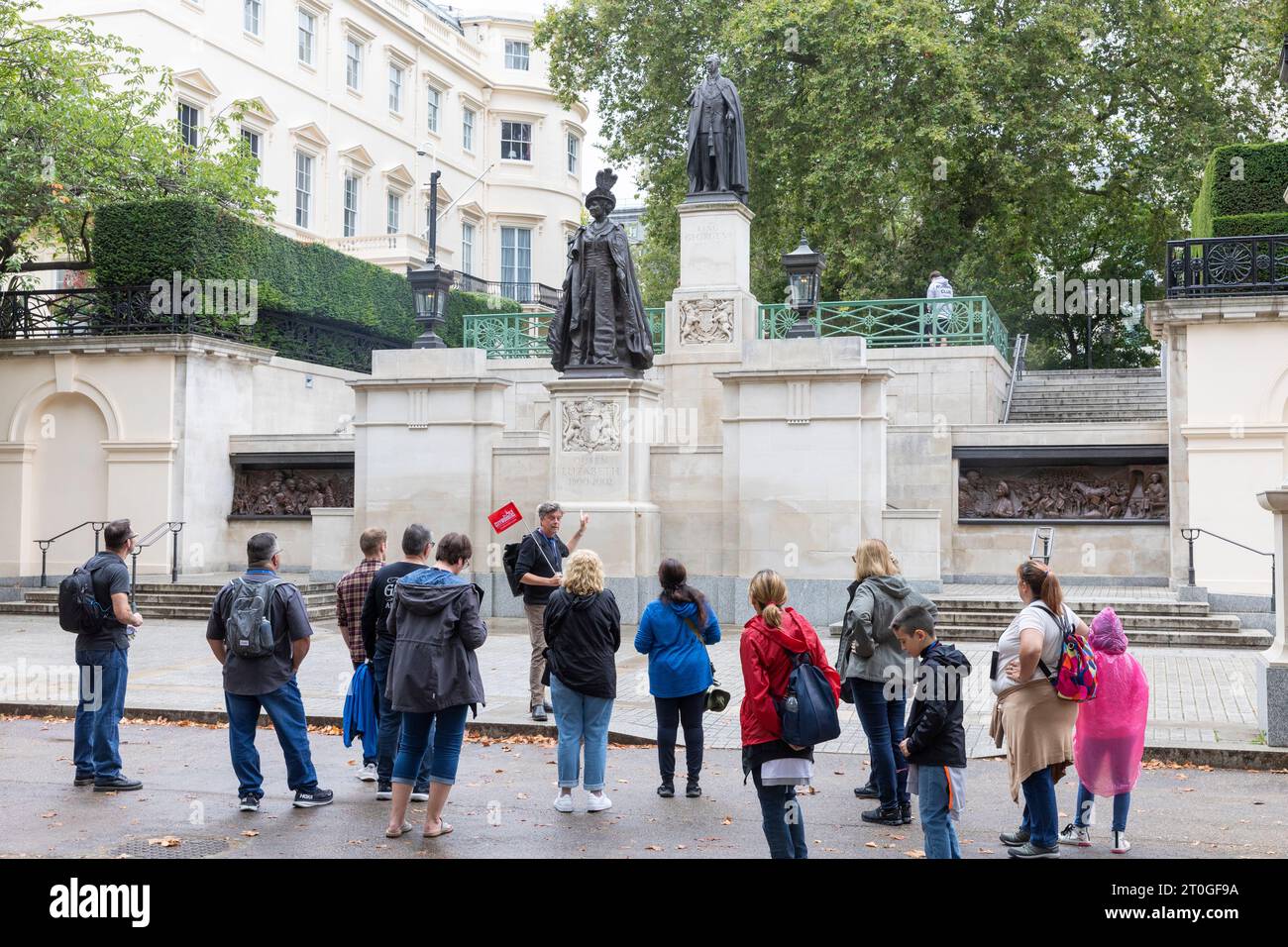 London the Mall, tour groups sightsee statues of Queen Elizabeth the Queen Mother and King George V1 on the Mall in London,England,UK Stock Photo