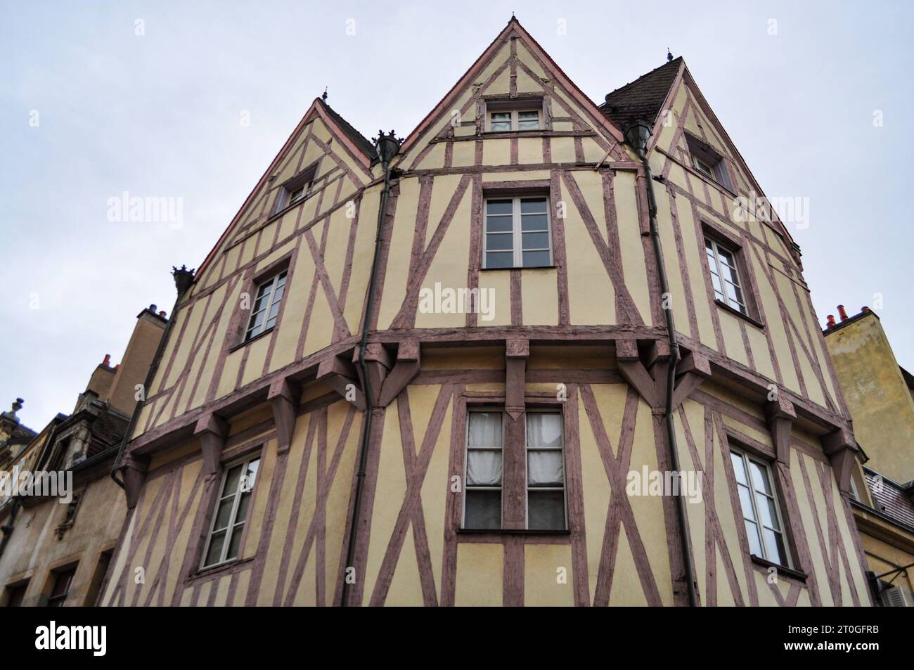 Half-timbered facade of houses in the old town of Dijon, France with three pointed triangular roofs Stock Photo