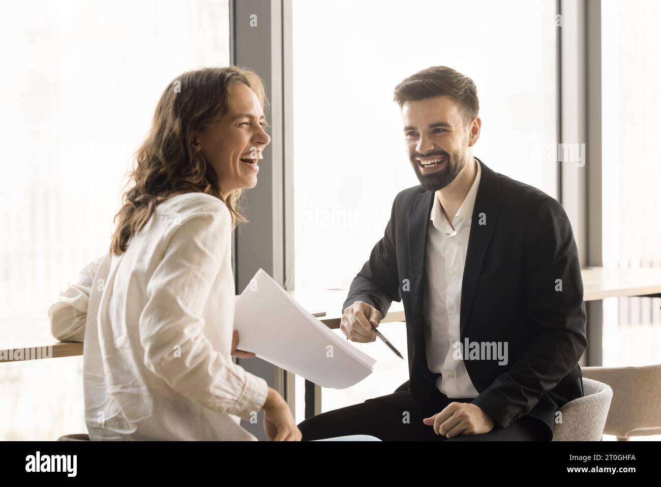 Cheerful young office friends brainstorming on project Stock Photo