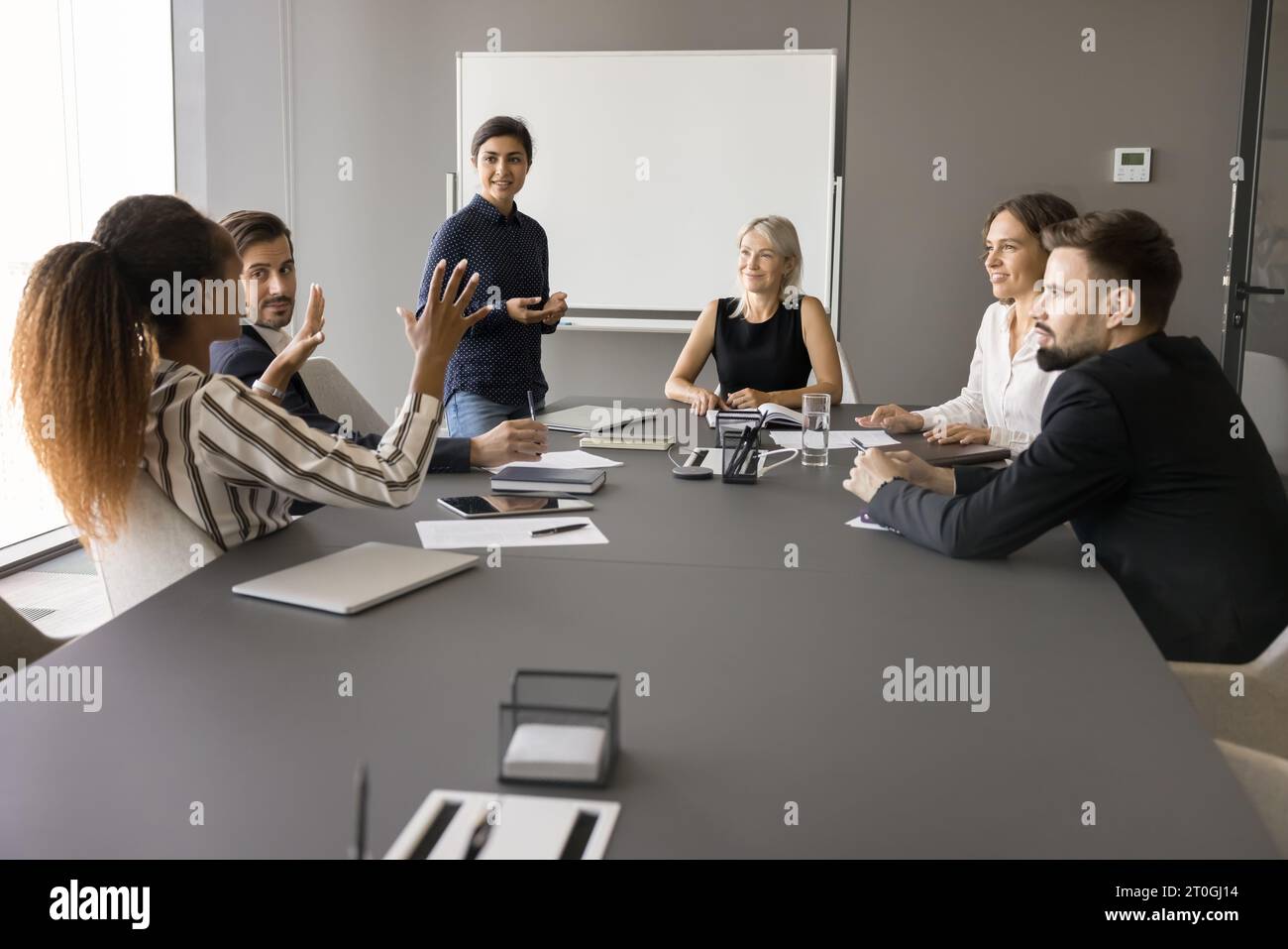 Diverse business team talking at meeting table in boardroom Stock Photo