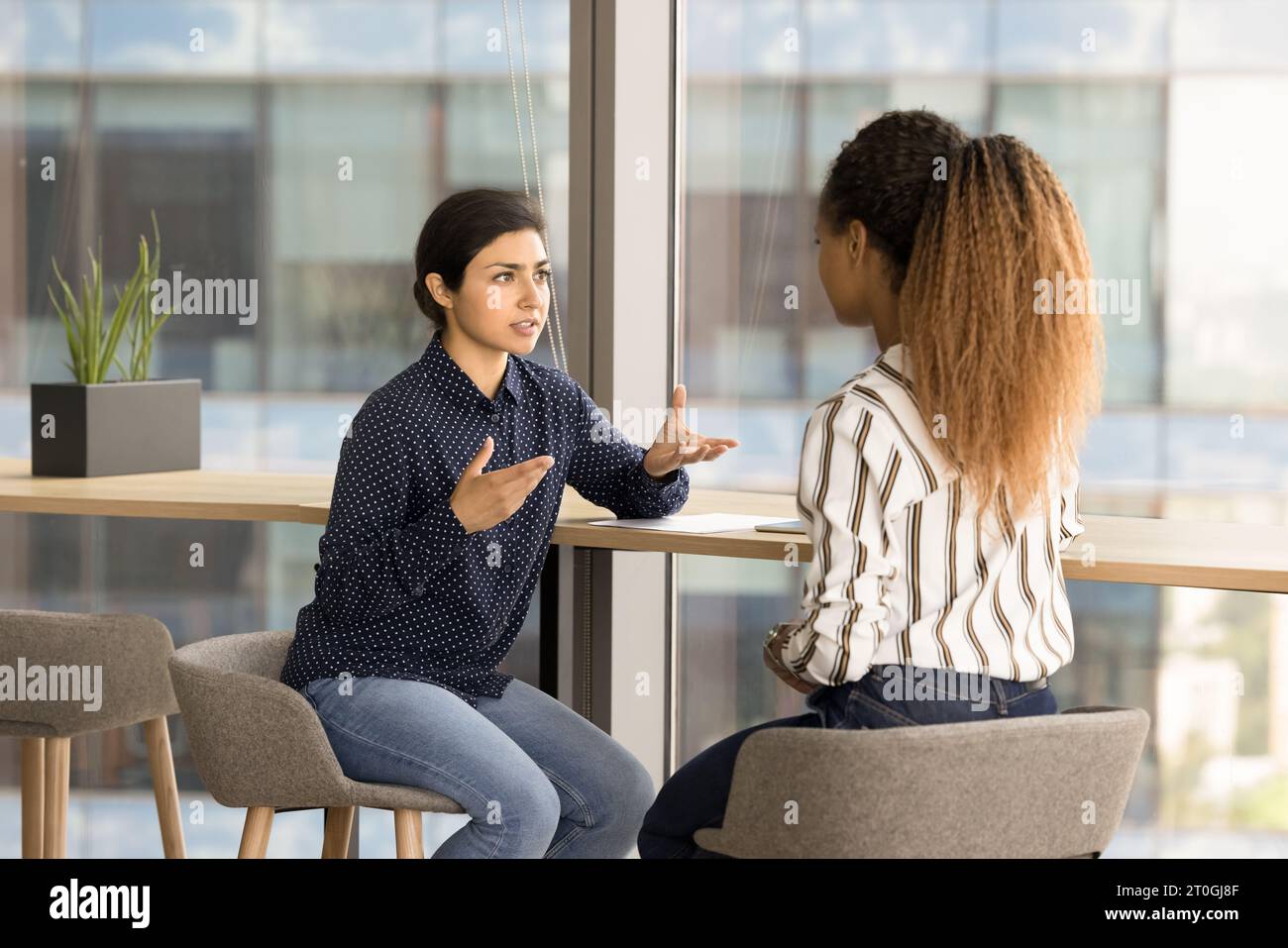 Serious young multiethnic project colleagues discussing collaboration Stock Photo